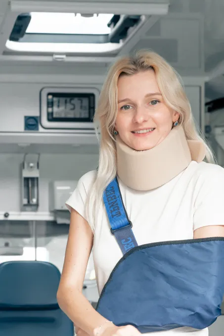 Frau im Krankenwagen mit verletztem Arm